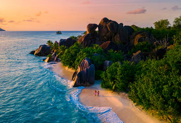 a couple walking on a tropical beach in the Seychelles