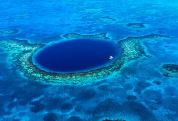 An aerial view of a boat moored in the Great Blue Hole off the coast of Belize.