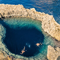 Above shot of two people snorkelling in Gozo's blue lagoon