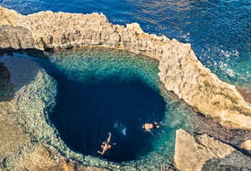 Above shot of two people snorkelling in Gozo's blue lagoon