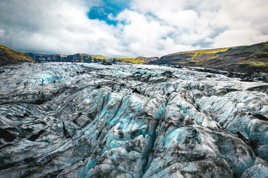 Ground view of a glacier expanse of Iceland with moss covered mountains