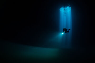 Deep sea diver in underwater cave.